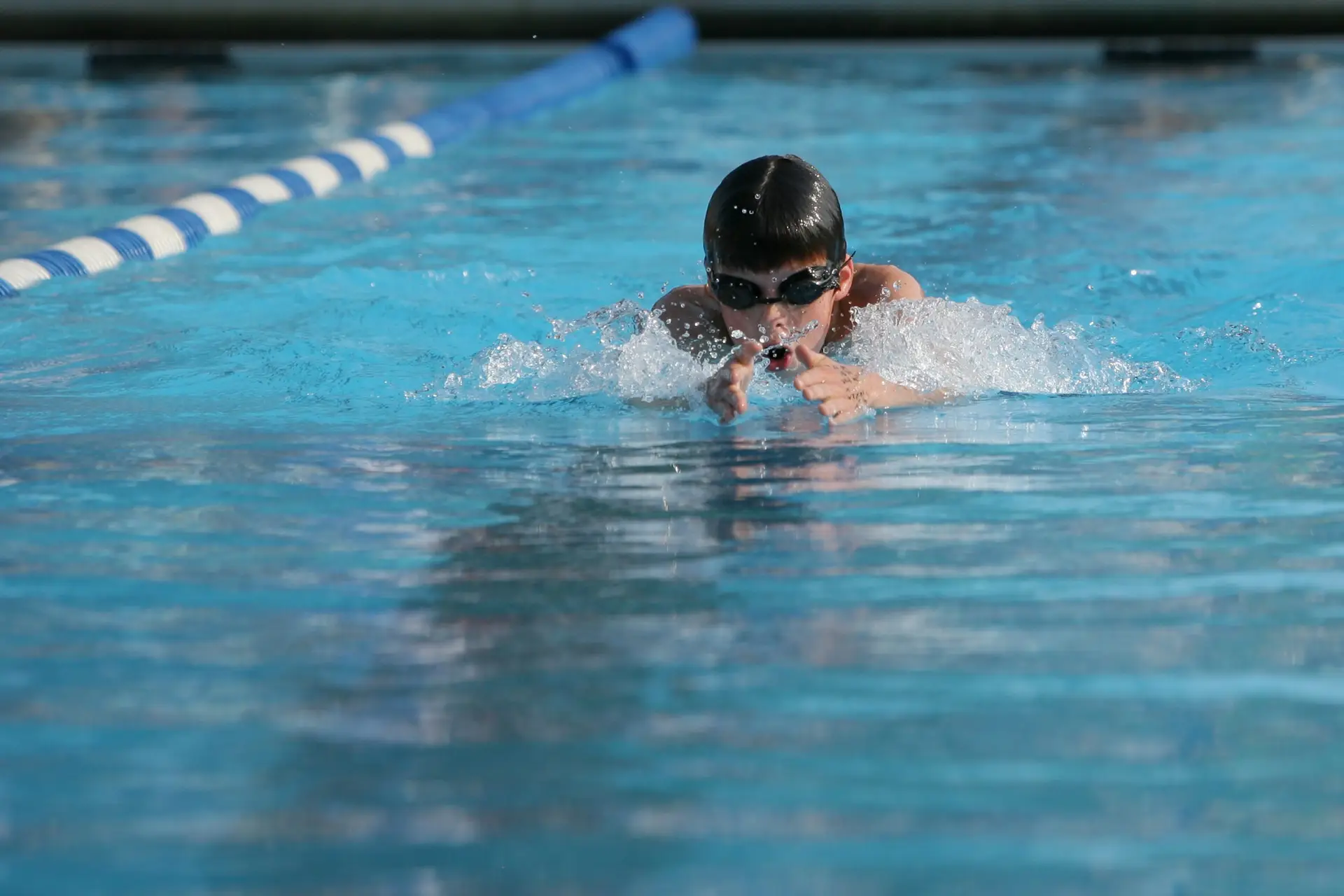 boy with goggles swimming in pool